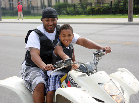 Father and son on Cool motorcycle at Glenville Parade