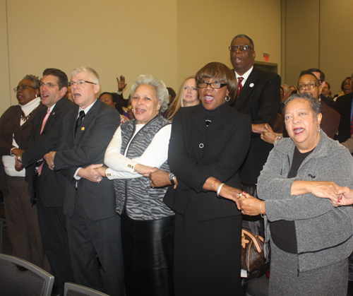 linked arms in group singalong of We Shall Overcome