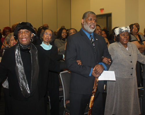 linked arms in group singalong of We Shall Overcome