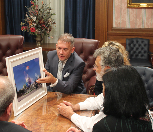 Artist Fate Velaj shows the photo to Mayor Jackson