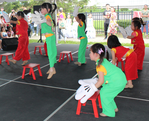 Young girls Chinese dance with big gloved hands