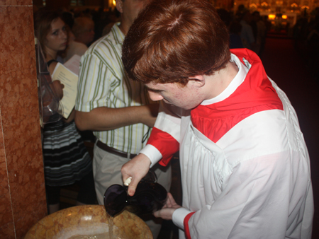 Filling the Holy Water containers with new blessed water