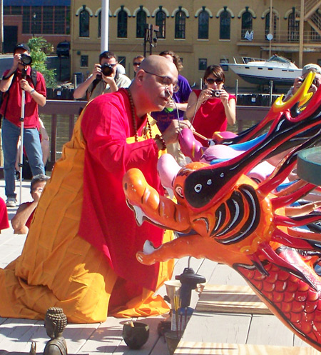 Buddhist Monk as Blessing Master of Dragon Boats paints the eyes of the dragons to awaken them