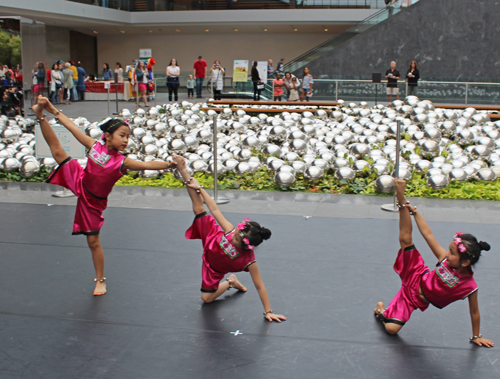 3 young girls doing an acrobatic Chinese dance