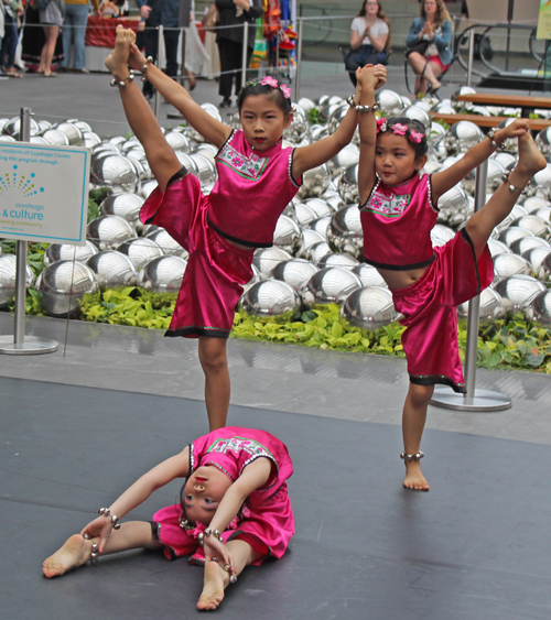 3 young girls doing an acrobatic Chinese dance