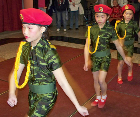 Young Chinese girls perform acrobatics in military costumes