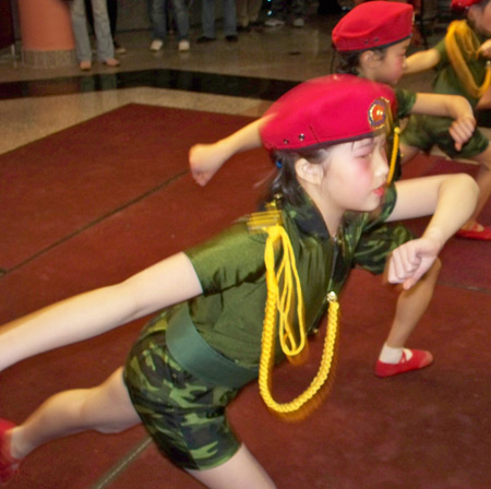 Young Chinese girls perform acrobatics in military costumes