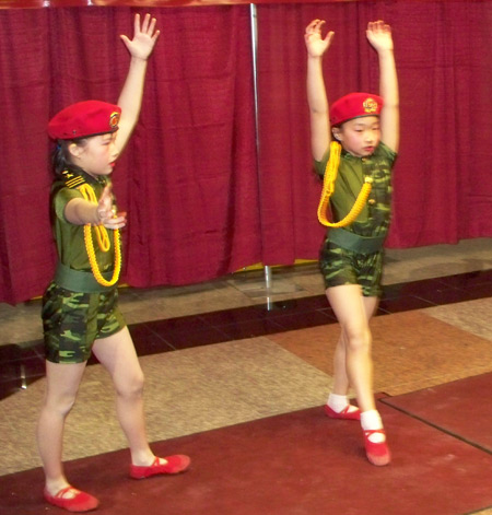 Young Chinese girls perform acrobatics in military costumes