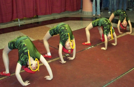 Young Chinese girls perform acrobatics in military costumes