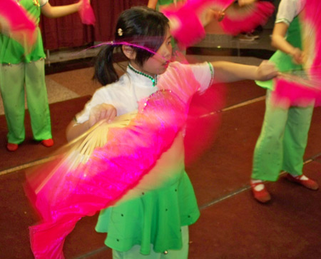 Young Chinese girls perform acrobatics with fans