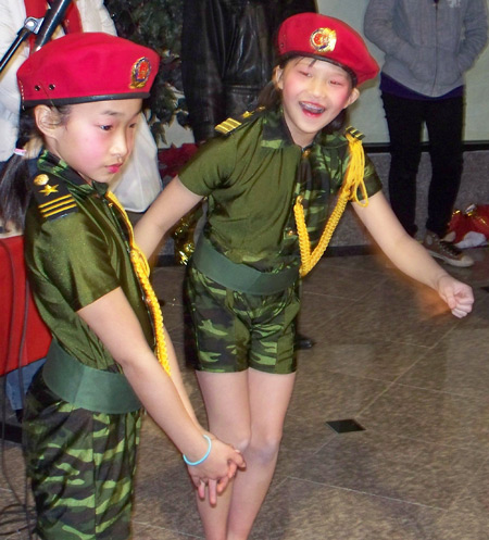 Young Chinese girls perform acrobatics in military costumes