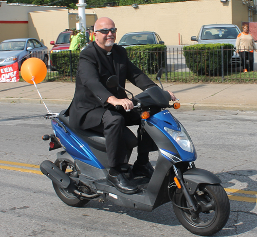 St Aloysius Priest on a bike in the parade