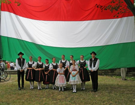 Hungarian kids in costume in front of Hungarian Flag