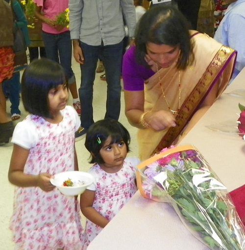 Indian American children bring flowers to the statue of Mary