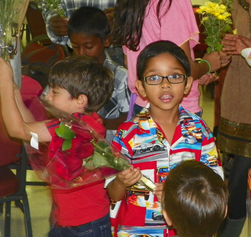 Indian American children bring flowers to the statue of Mary