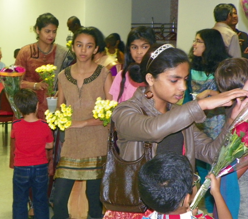 Indian American children bring flowers to the statue of Mary