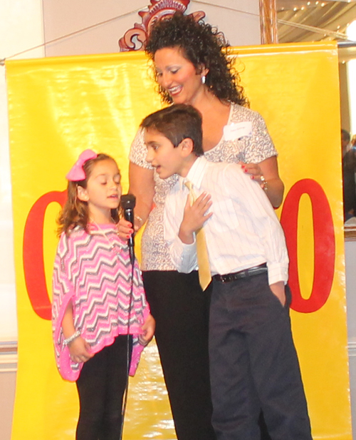 Amy George and children sing the National Anthem