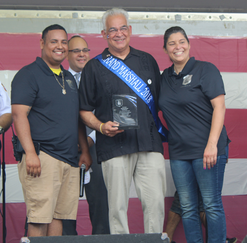 Officer Freddy Diaz and Detective Lisette Gonzalez with Grand Marshall Michael Ferrer 