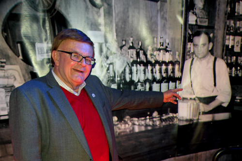 Tony Petkovsek points out a vintage photo mural of his father, Tony Sr., at his Birch Bar