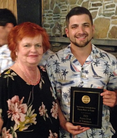 Garrett Tatano receives a plaque as the Polka Star of Tomorrow by Sharon Staiduhar, a trustee of the National Cleveland-Style Polka Hall of Fame