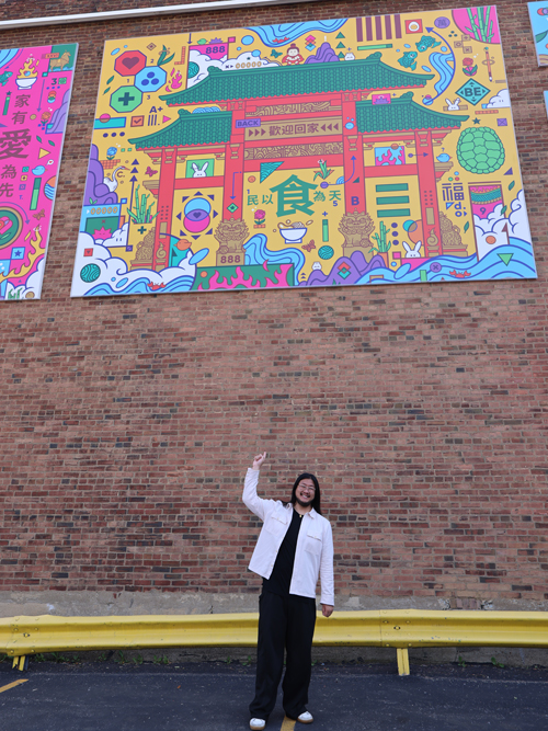 Jordan Wong pointing to his latest mural