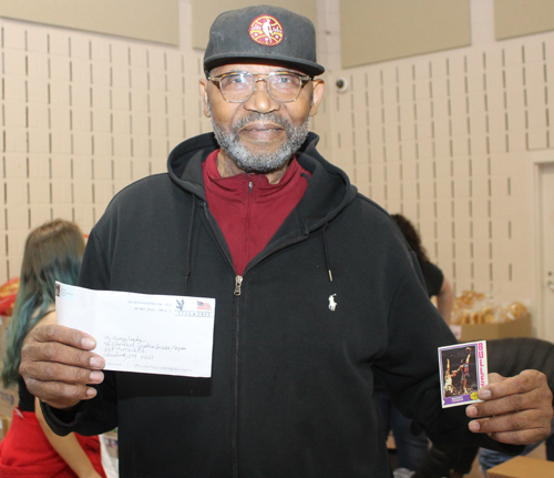 Manny Leaks holding a trading card that a fan sent him