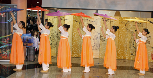 Teen girls perform a Chinese Dance with parasols at Lunar New Year