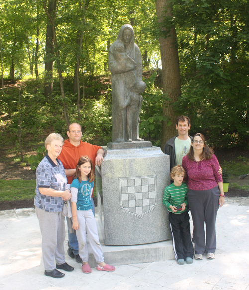 Members of the Turkaly family with the Immigrant Mother statue in the Croatian Cultural Garden