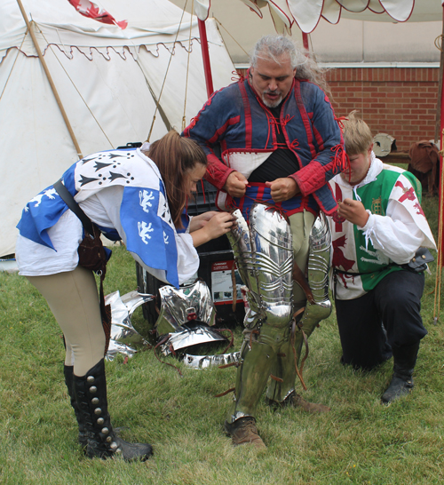 Knight putting on armor to prepare for joust