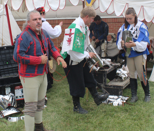 Knight putting on armor to prepare for joust