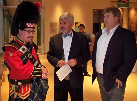 Paul Burik and Dan Hanson check out the bagpiper