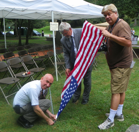 Ray Saikus, Paul Burik and Dan Hanson help with the flag