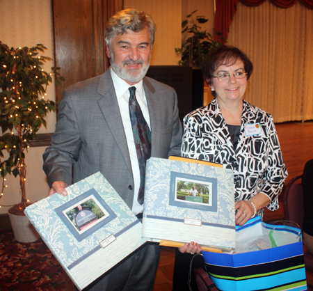 Fran Burik presenting scrapbooks to Paul Burik