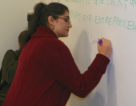 Arooj Ashraf signs the Global Cleveland Welcome Center wall