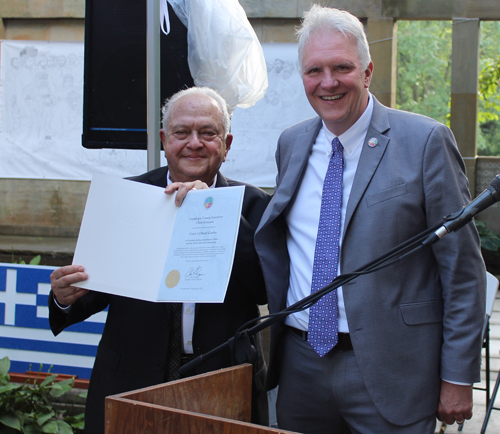 Chris Ronayne gives a proclamation to Lou Frangos