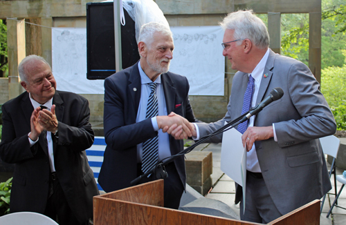 Chris Ronayne gives a proclamation to Deputy Minister Loverdos