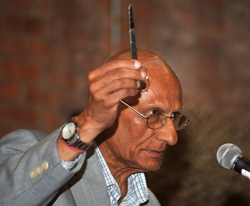 Ramesh Shah showing scissors he used to cut hair