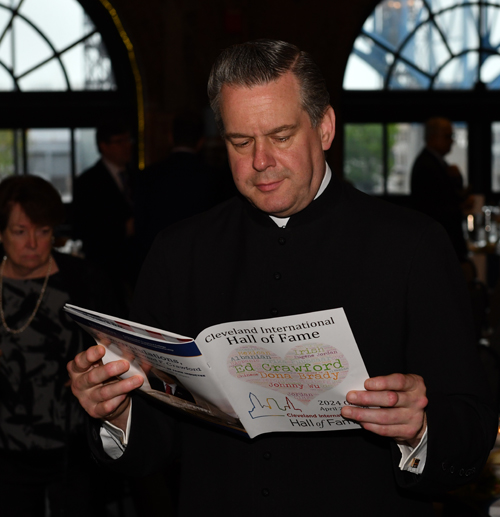 Fr. Eric Orzech reading the program book