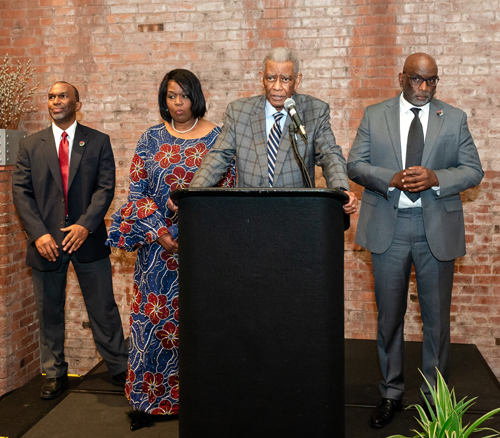 Rev Moss Jr. inducts Dr. Eugene Jordan with his children on stage