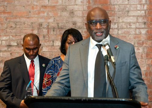 Rev Moss Jr. inducts Dr. Eugene Jordan with his children on stage