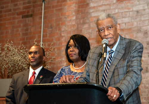 Rev Moss Jr. inducts Dr. Eugene Jordan with his children on stage