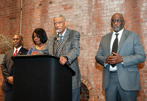 Rev Moss Jr. inducts Dr. Eugene Jordan with his children on stage