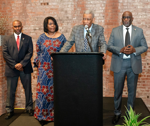 Rev Moss Jr. inducts Dr. Eugene Jordan with his children on stage