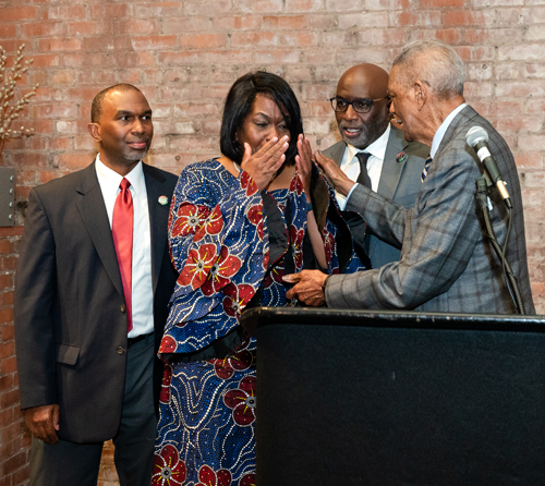 Rev Moss Jr. inducts Dr. Eugene Jordan with his children on stage