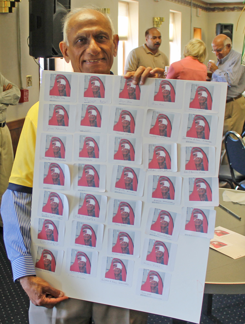 AIPNO leader Ramesh Shah holds a sign showing the number of cataract surgeries that were sponsored that morning.
