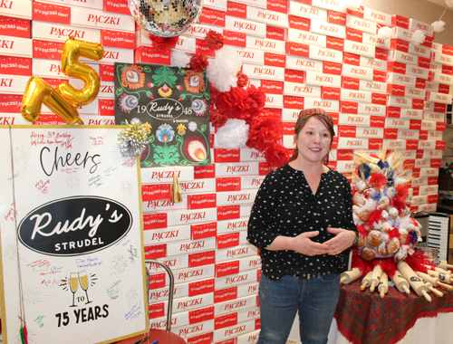 Lidia Trempe in front of a wall of paczki boxes