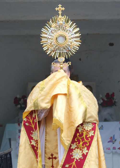 Father Eric Orzech carrying the monstrance on Corpus Christi