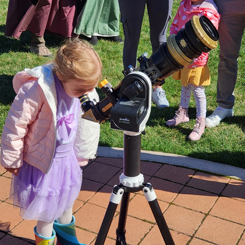 Little girl looking through Telescope at Polish Center