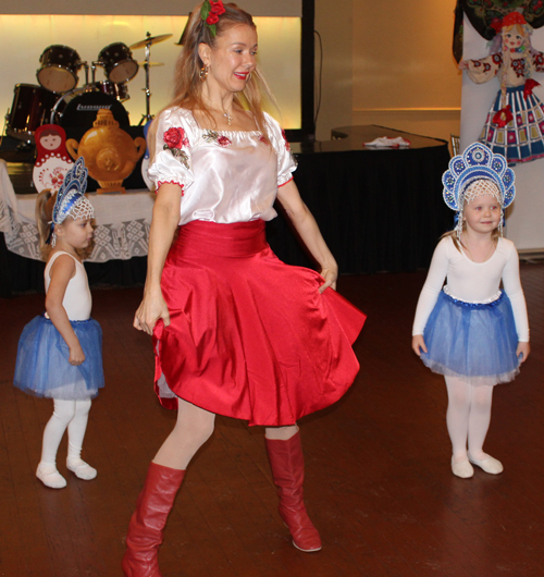Alena Reshetnikova from the Paprika Dance Ensemble with two young girls