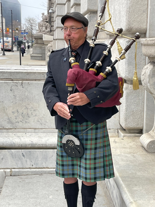 Bruce Greig piping outside the library